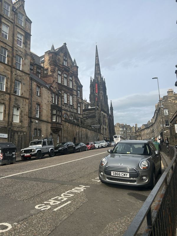 A stone street climbing toward a tall gothic spire
